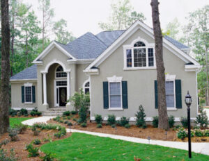 Exterior view of a beautiful home with windows, shutters, and an attractive front door