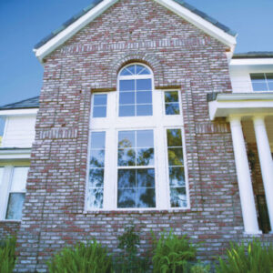 Exterior view of a largely picture window on a luxurious brick house